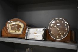 A 1940's walnut mantel clock of arched design with stepped sunburst elements and Arabic hours,