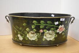 A Victorian toleware style planter, of oval form with two carrying handles, and raised on four