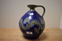 An early to mid-20th Century stoneware ewer, decorated with a stylised and incised banded design