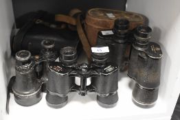 Three pairs of early-mid 20th Century binoculars and two cases, to include a pair by Dixey & Sons