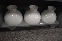A group of three milk glass lamp shades, of hemispherical form with short flared top