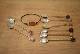 A set of eight white metal teaspoons, of twisted design with a semi-precious stone to the terminals,