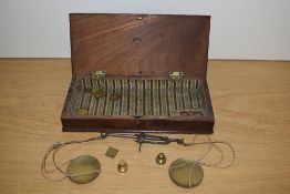 A set of 19th Century apothecary scales and weights, displayed within a mahogany hinged box