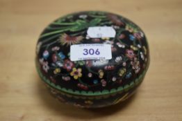 A Chinese cloisonné enamel circular box, decorated with blossoms against the back ground, 11cm