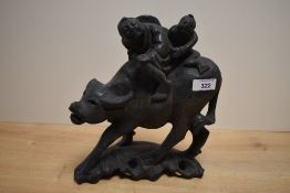 A Chinese carved hardwood figure group, a man and child riding a water buffalo, the surface inset