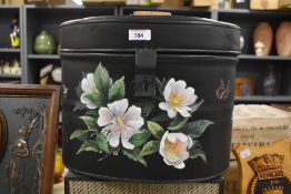 A 20th Century toleware style hat tin, hand painted with a foliate design and measuring 32cm high