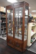 A modern Chinese glazed hardwood display cabinet, having a tablet moulded top section housing