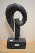 A cast and chemically patinated metal sculpture, of abstract form, possibly brass or bronze 38cm