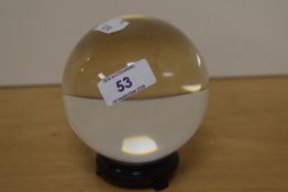 A crystal ball on stand, measuring 12cm high with a diameter of 10cm