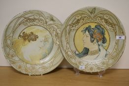 A pair of late 19th Century hand painted tin plates, decorated in the Art Nouveau style with head