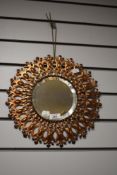 A 1970s copper Sunburst style mirror, measuring 34cm in diameter