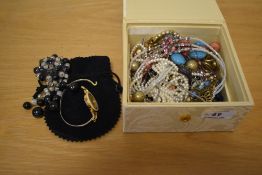 A cream damask pattern jewellery box, containing an assortment of costume jewellery including