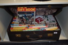 A suitcase containing various books of sporting interest including cricket, titles including '