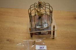 An unusual gilt metal and clear perspex musical bird cage automaton, damage and bending to two '
