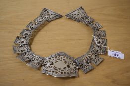 A 1920s silver plated articulated belt, having panels of pierced scroll motif with a banded edges,