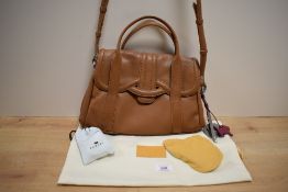 A ladies tan leather Radley of London handbag, with foliate lined interior, material outer bag and