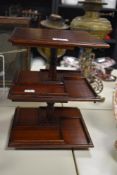 A reproduction mahogany three tiered revolving CD stand, of square section and measuring 30cm high