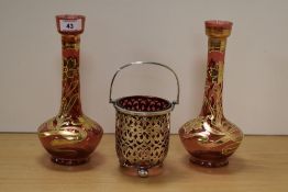 A pair of 19th/20th Century Bohemian ruby glass vases, hand painted with a gilt foliate design and
