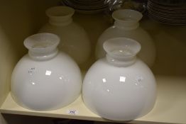 Four Victorian milk glass oil lamp shades, each measuring 21cm high