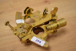 A brass nautical sextant instrument, measuring 17cm wide