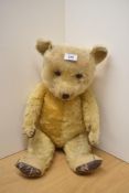 A mid 20th century straw filled yellow plush Teddy Bear having plastic eyes, stitched nose &