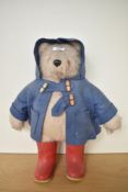 A Gabrielle Designs Paddington Bear having plastic eyes and nose, wearing blue jacket and red