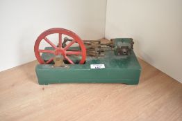 A unnamed stationary horizontal Steam Engine, single single engine, spoked flywheel, on wood base