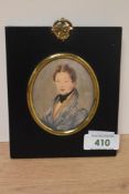 19th Century School, a portrait miniature of a young gentleman wearing a blue overcoat, set within