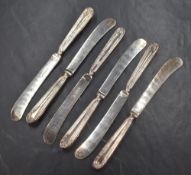 A cased set of George V silver handled butter knives, having decorative embossed scroll work with