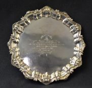 An Edwardian silver presentation salver, having a scalloped c-scroll rim with a central engraving,