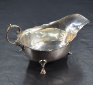 A George V silver sauce boat, with Chippendale style rim, generous spout opposed by a decorative