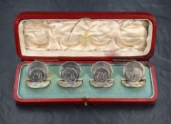 A set of four Edwardian silver place card holders, of circular form having 'EB' monogram engraved,