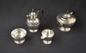 A George V silver four-piece tea set comprising a tea pot, hot water pot, sugar and cream, all of