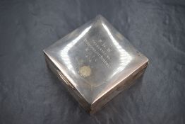 A George V silver cigarette box, of hinged square form with 'P.W.W. Presented By Stramongate