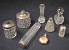 An assortment of silver mounted and capped cut glass vanity table wears, comprising scent bottles