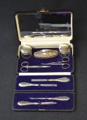 A cased George V silver mounted and handled travel manicure set, with two pairs of steel scissors,