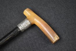 A late Edwardian silver mounted walking stick, the dark wood cane with silver ferrule and possibly
