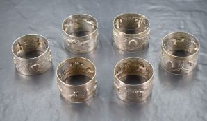 A group of six Eastern white metal napkin rings, depicting various animals including elephants,