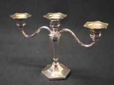 An Elizabeth II silver three-branch candlestick, of turned and hexagonal form, the central column