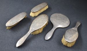 A George V silver mounted vanity set, comprising two hair brushes, two clothes brushes and a mirror,