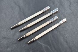 A cased set of four silver bridge mechanical pencils, having engine turned decoration and each