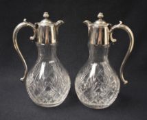 A pair of silver plate mounted cut glass decanters, of bulbous form with flower bud finial and