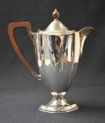 A George V silver coffee pot of oval form, having a short spout opposed by an angular handle, with