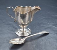 A George V silver cream jug, having a lobed rim with a narrow spout opposed by a scroll handle,