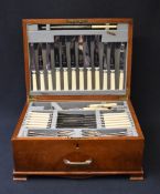 A mid 20th century canteen of 12 place settings having brass handle and four carved feet, containin