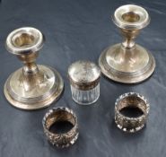A pair of George V silver weighted candlesticks, of stout form with step line detail having round