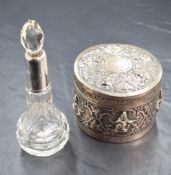 An Eastern white metal powder pot, thought to be Thai, having embossed figures in traditional