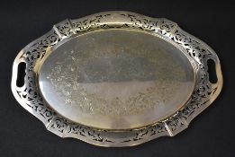 A large silver plated serving tray, of oval form with pierced scroll rim having shield cartouches to