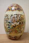 A large Eastern decorative pottery egg, decorated in polychrome with landscape and crane vignettes