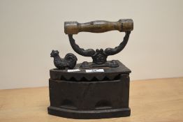 An ornamental cast-iron box iron, with turned wooden handle and chicken form latch, marked OTS,